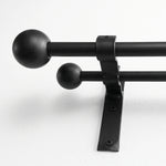 Wrought iron curtain pole hanging on wall in white finish