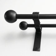 Wrought iron curtain pole hanging on wall in white finish