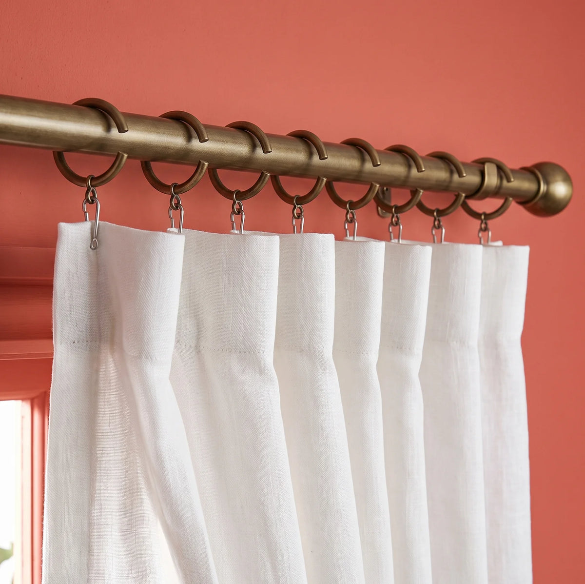 Wrought iron curtain pole with curtains hanging in a home