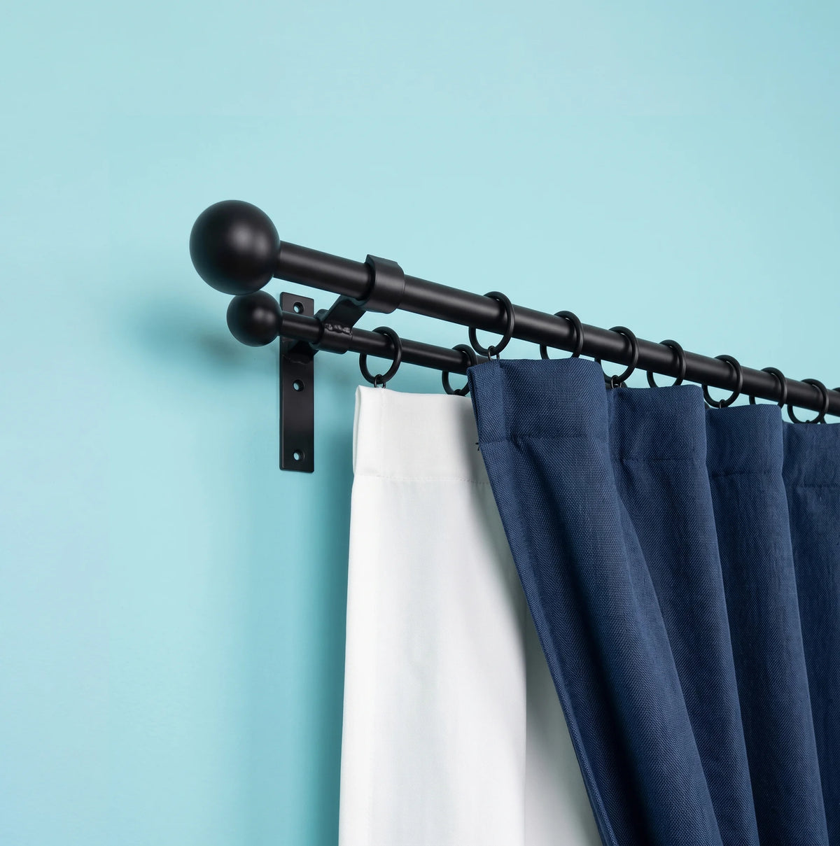 Wrought iron curtain pole with hanging curtains in a stylish interior