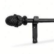 Black wrought iron curtain pole with decorative finial and mounting bracket