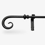 Wrought iron curtain rings being removed from a curtain pole