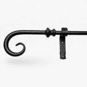 Wrought iron curtain rings being removed from a curtain pole