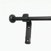 Wrought iron curtain rings being removed from a curtain pole